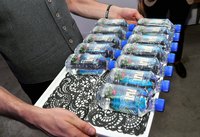 A server carrying a tray of mineral water imported from Fiji.
