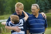 A man with his arm around his father and son.