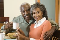 A retired couple sitting at the breakfast table.