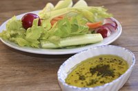 Salad with vinagrette dressing in a small bowl.
