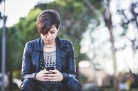 A teenager looking down at her smart phone.