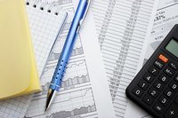 Close-up of calculator over business paperwork