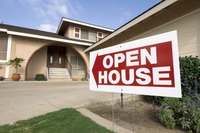 House for sale with an "open house" sign in front yard.