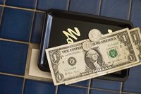 An overhead view of a cash tip on a bill tray in a cafe.