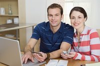 A man and woman are working at their computer.