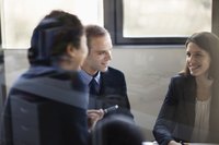 Three collegues having a discussion in a conference room.