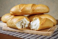 Freshly baked loaves of bread on cutting board.