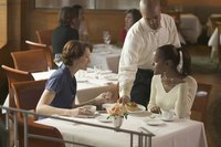 Waiter serving woman diners.