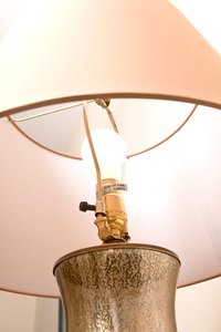 Use paint or wallpaper to darken your fabric lampshades.