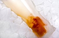 Glass of freezing beer in pile of ice.