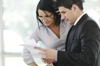 A man and woman are going over a business report.