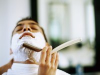 Man getting shaved by a barber.