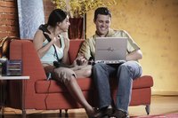 A man and woman are using their computer at home.