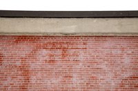 Brick veneer attaches over top of stucco.
