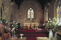 Use large floral arrangmenets to decorate a church altar.