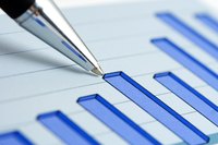 A pen pointing at stock charts.