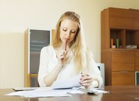 Woman looking over bills with a calculator