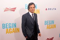 An actor standing in front of a wall at a company sponsored event.