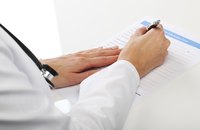 A doctor is writing on a bill.
