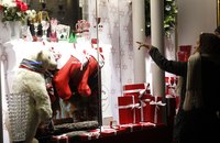 A woman pointing at a Christmas window display in Paris, France.