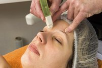 A client receiving an eyebrow wax in a salon.