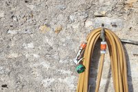 Close-up of garden hose hanging on wall.