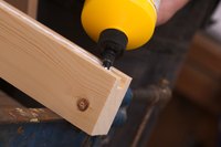 Carpenter applying glue to a piece of wood.