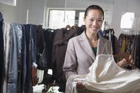 A female sales associate sorts through inventory at a clothing store.