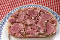 Sliced piece of head cheese on plate.