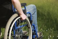 Close-up of person in wheel chair in grass field
