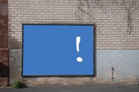 The beginning of an advertising poster is set up against a brick wall ready to be painted for display