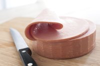 Sliced bologna on cutting board.