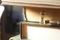 A "LOVE" note tucked inside of a tiny jar on a stack of books.
