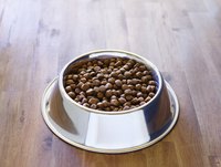 A bowl of dog food on a wood floor.