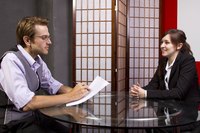 A man interviewing a young woman for a job