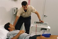 A man is in a rehabilitation facility with a therapist.