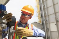 An engineer at work wearing safety glasses and a helmet