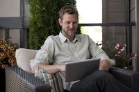 A man reading an email on the patio.