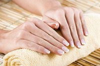 Close-up of healthy looking hands and nails resting on a towel.