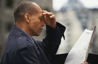 Man reading penny stock patterns in a newspaper.