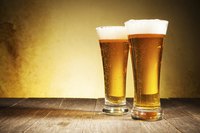 Two glasses of beer on a wood table.