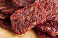 A close-up of beef jerky on a cutting board.