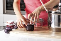 Woman sealing a jar of jam.