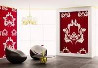 A modern living room composed of leather chairs and white damask designs on red walls.