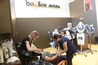 Woman getting a manicaure and facial at an Aveda salon.