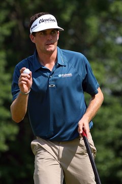 Keegan Bradley wears traditional men's golf attire at a 2011 PGA event: slacks plus a collared shirt tucked into his pants.