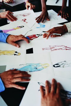 Close up of Hands on a Table With a Fashion Designer's Drawings