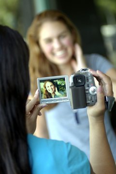 Teenage girls using video camera