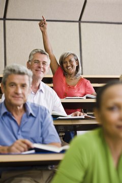 Student raising hand in lecture hall