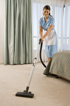 Maid vacuuming carpet